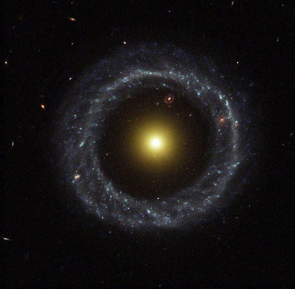 Cincin bintang biru mengelilingi inti galaksi kuning (commons.wikimedia.org/NASA and The Hubble Heritage Team)