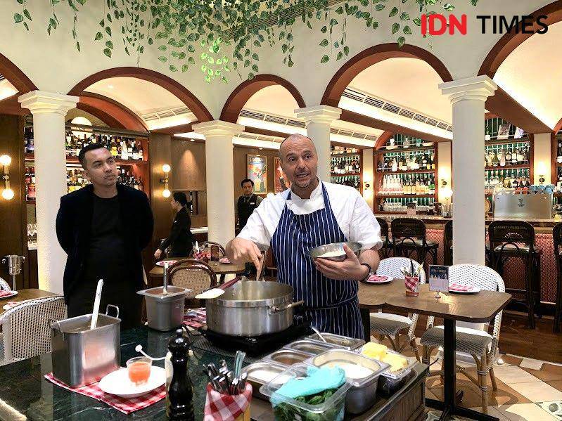 Potret Chef Tommaso menyajikan Black Ink Risotto di Osteria Gia Surabaya pada Selasa (20/5/2025) (IDN Times/Fasrinisyah Suryaningtyas)