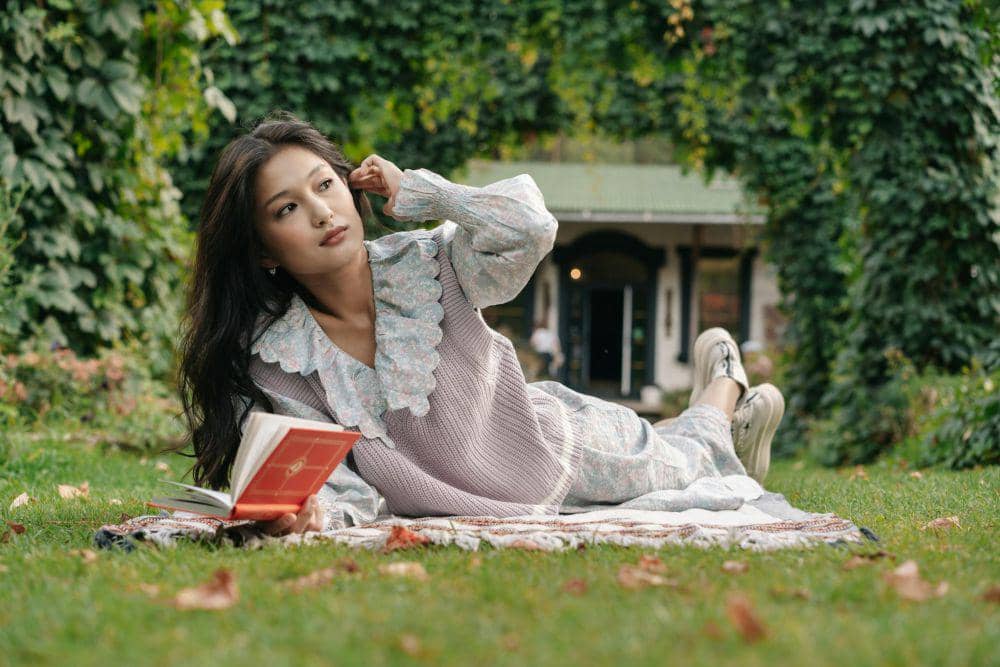 ilustrasi wanita membaca buku di taman (pexels.com/Mikhail Nilov)