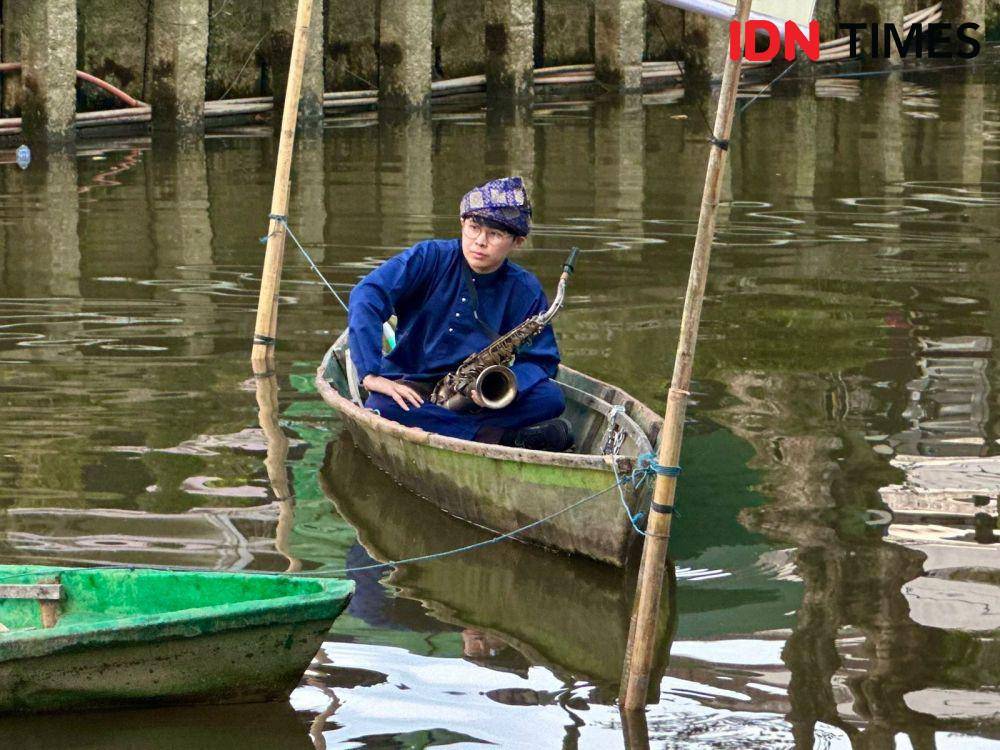 Sejumlah pemusik mainkan alat musik tiup di atas sampan. (IDN Times/Teri).