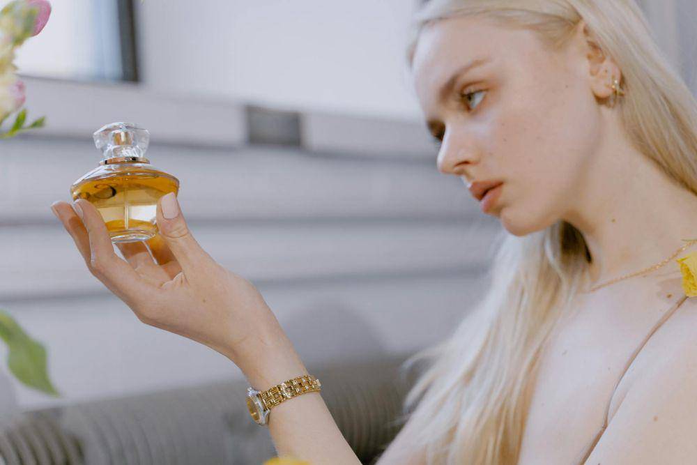 ilustrasi seorang wanita sedang memakai parfum (pexels.com/MART PRODUCTION)