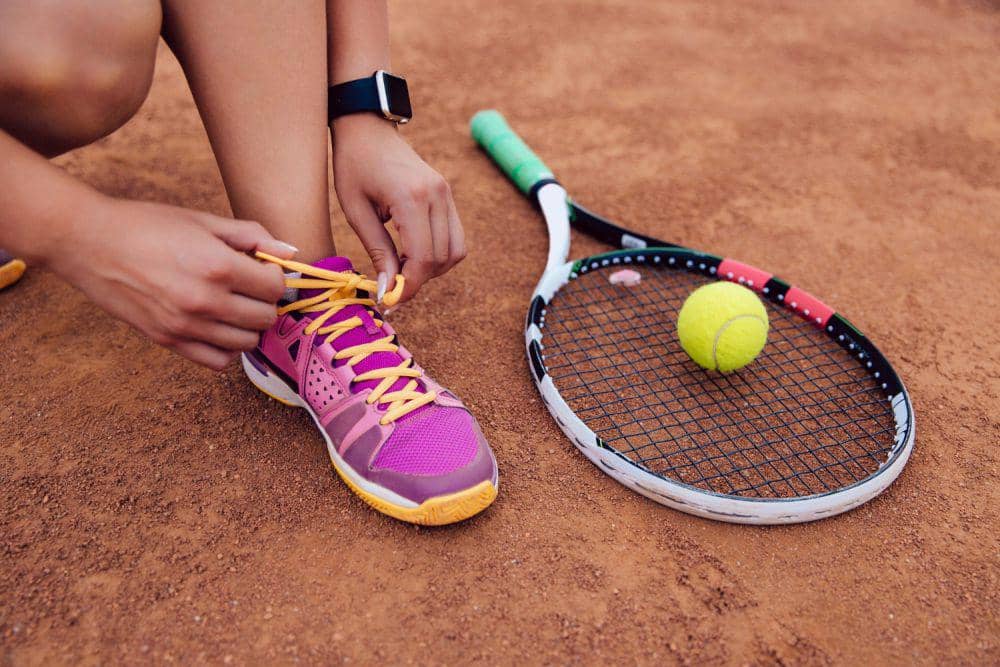 Ilustrasi sepasang sepatu tenis yang ditampilkan sebagai perlengkapan olahraga untuk bermain di lapangan.