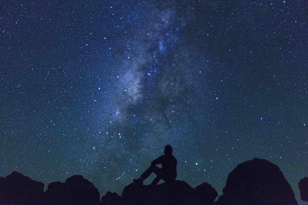 Orang di bawah langit berbintang (thoughtco.com)