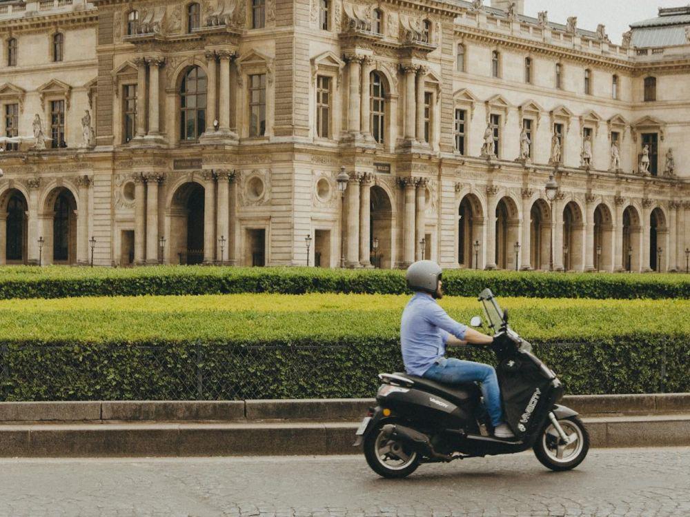 pria mengendarai motor matic