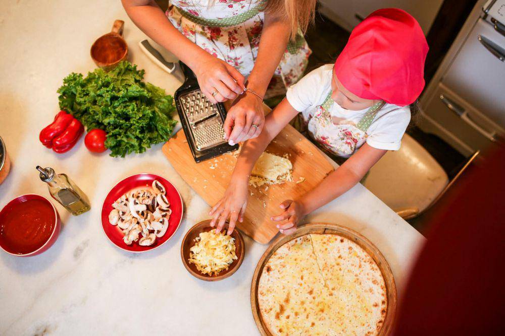 ilustrasi anak menyusun topping di atas pizza (pexels.com/RDNE Stock project)