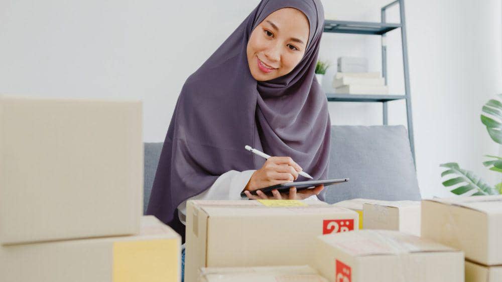 Ilustrasi mencatat pengeluaran (freepik.com/Young muslim businesswoman check product purchase order on stock and save to tablet computer work at home office. tirachardz)