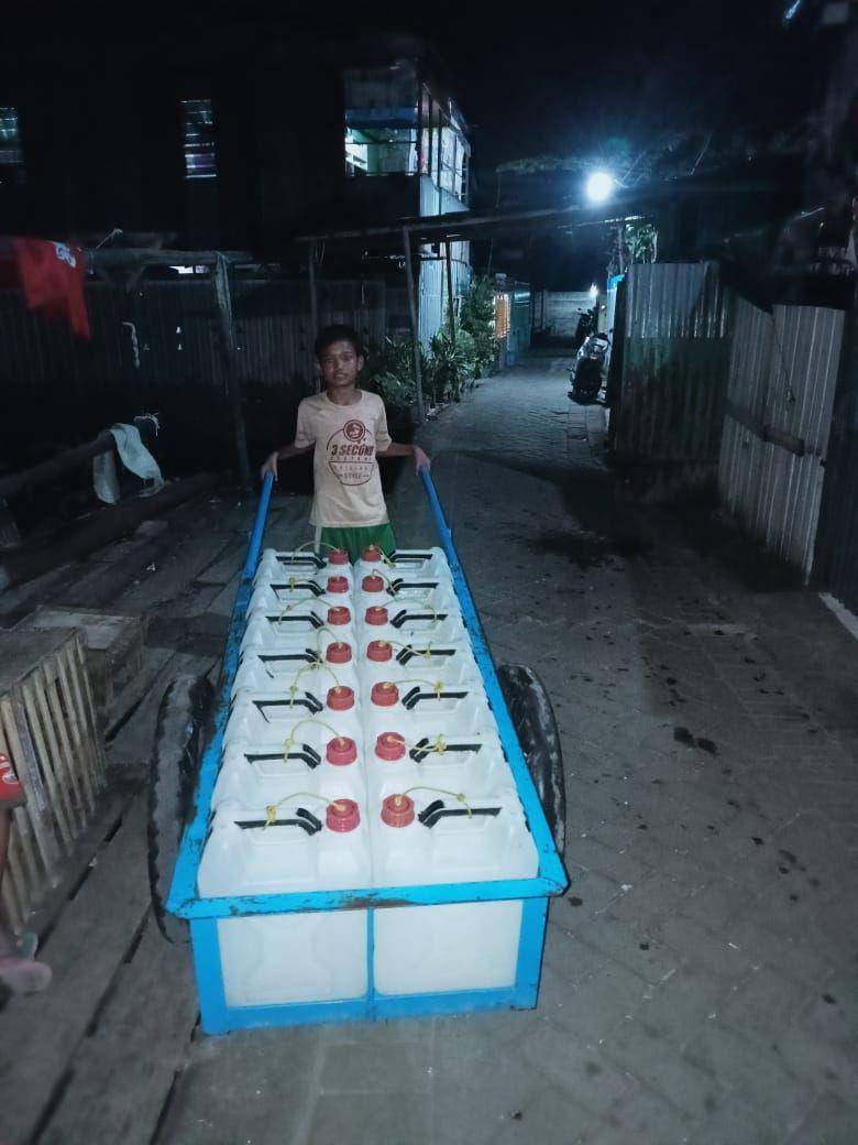 Seorang anak di Kampung Buloa Makassar mendorong gerobak berisi jeriken air bersih, Mei 2025/Dokumentasi Warga Buloa