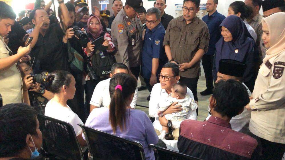 Menteri P2MI Abdul Kadir Karding menggendong salah satu anak dari PMI ilegal yang dideportasi Malaysia (IDN Times/ dok BP3MI Riau)