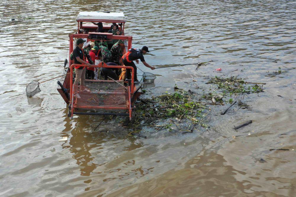 Prajurit TNI bersama warga menjaring sampah yang berada di aliran muara Sungai Karang Mumus di Samarinda, Kalimantan Timur, Sabtu (31/5/2025). ANTARA FOTO/M Risyal Hidayat/agr