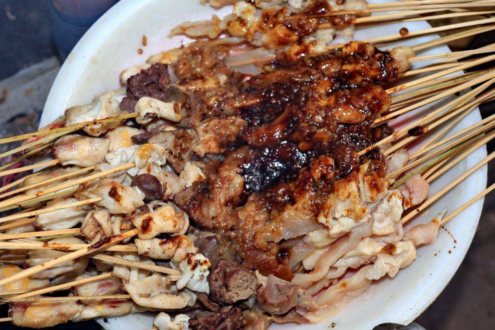 Ilustrasi membumbui sate dengan kecap (vecteezy.com/Onyengradar)