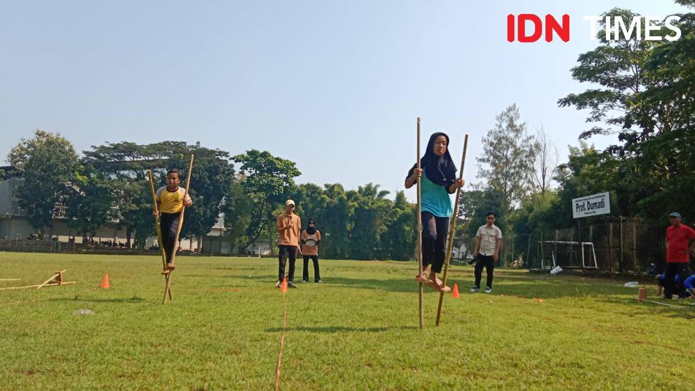 Dua siswa dan siswi juga tak mau kalah beradu kecepatan dalam ajang balap egrang beregu kategori pelajar SD yang diadakan oleh FIK Unnes dalam gelaran Festival Dolanan Bocah. (IDN Times/Fariz Fardianto)