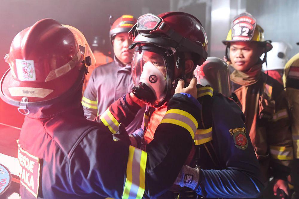 Relawan pemadam kebakaran mengenakan alat pelindung diri (APD) saat melakukan pembasahan ketika terjadinya kebakaran di Big Mall Samarinda, Kalimantan Timur, Selasa (3/6/2025) dini hari. ANTARA FOTO/M Risyal Hidayat/nz