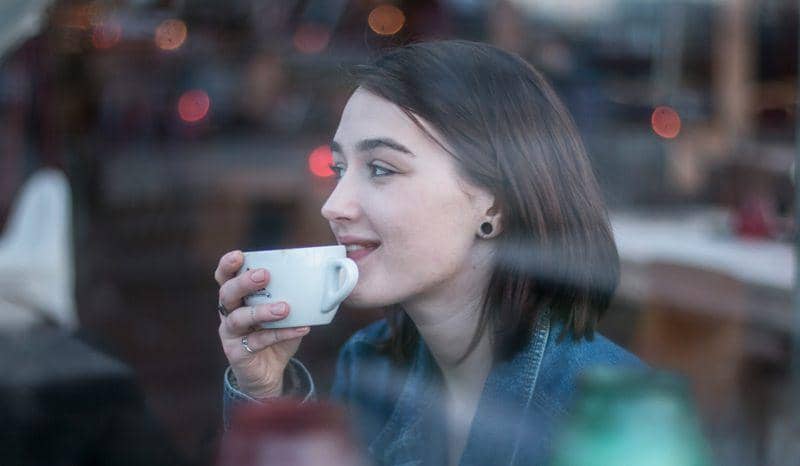 ilustrasi seorang perempuan sedang minum segelas kopi (unsplash.com/Mikail Duran)