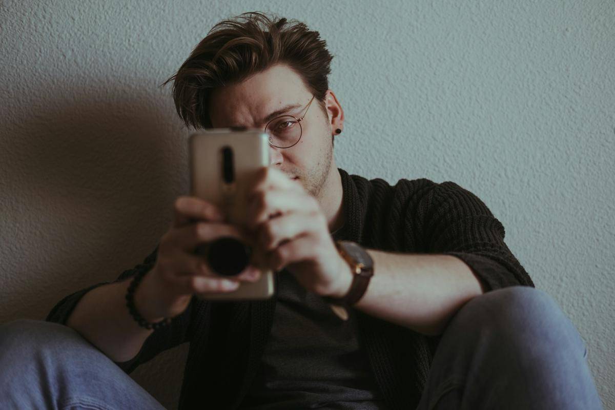 Ilustrasi pria bermeain handphone (unsplas.com/Joshua Reddekopp)