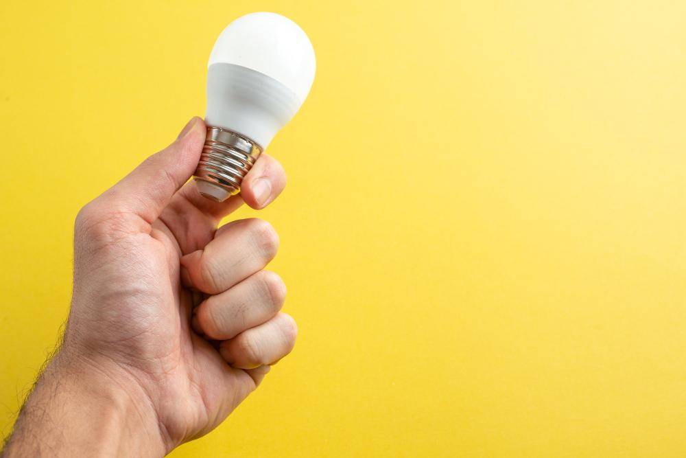 Ilustrasi tangan memegang bolam lampu (freepik.com/mdjaff)