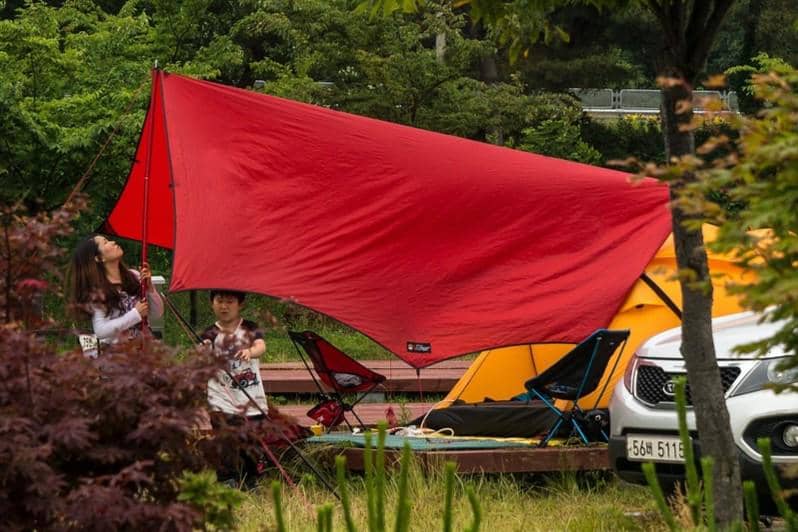 ilustrasi orang memasang flysheet 