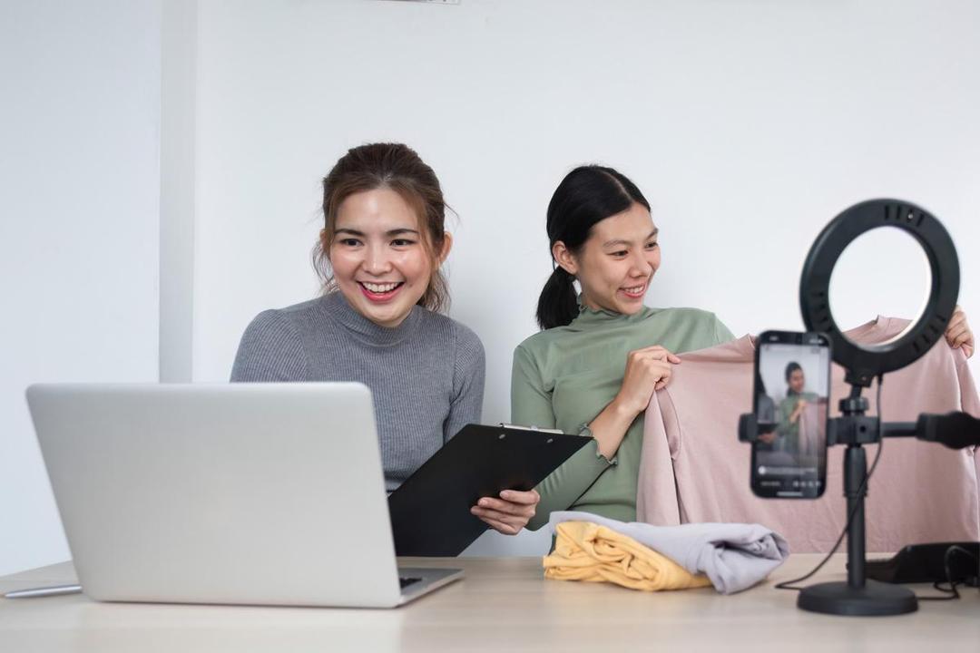 Ilustrasi dua perempuan melakukan live shopping