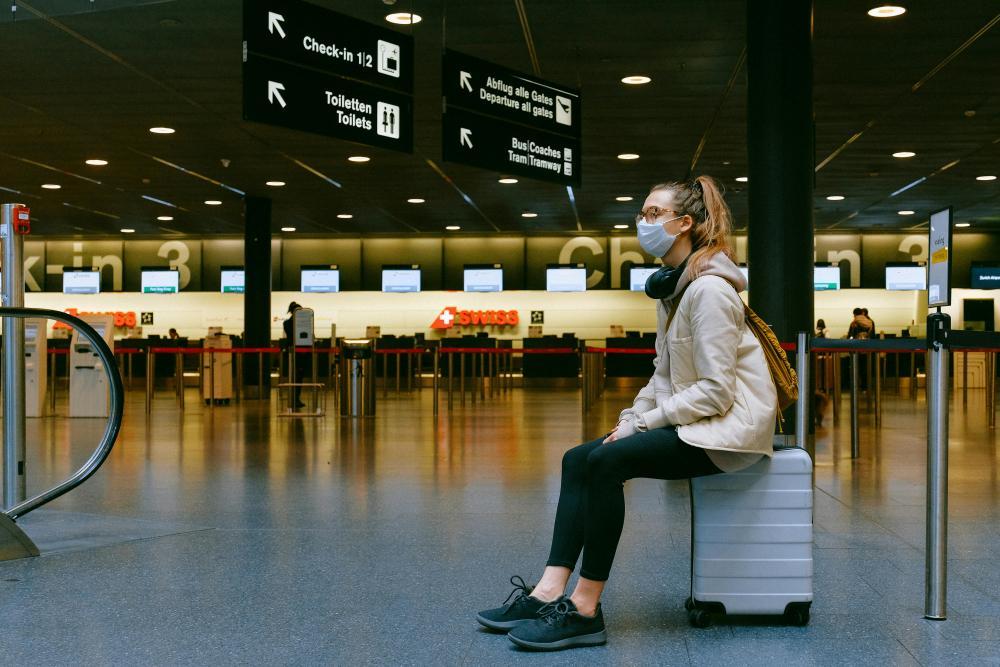https://www.pexels.com/photo/woman-sitting-on-luggage-3943882/