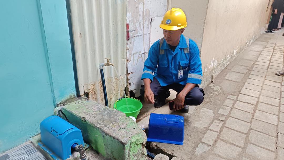 Petugas PDAM memasang sambungan baru di salah satu rumah warga penerima manfaat program sambungan air gratis di Lorong 4, Jalan Monumen Emmy Saelan, Kelurahan Tidung, Kecamatan Rappocini, Makassar, Kamis (26/6/2025). (IDN Times/Asrhawi Muin)