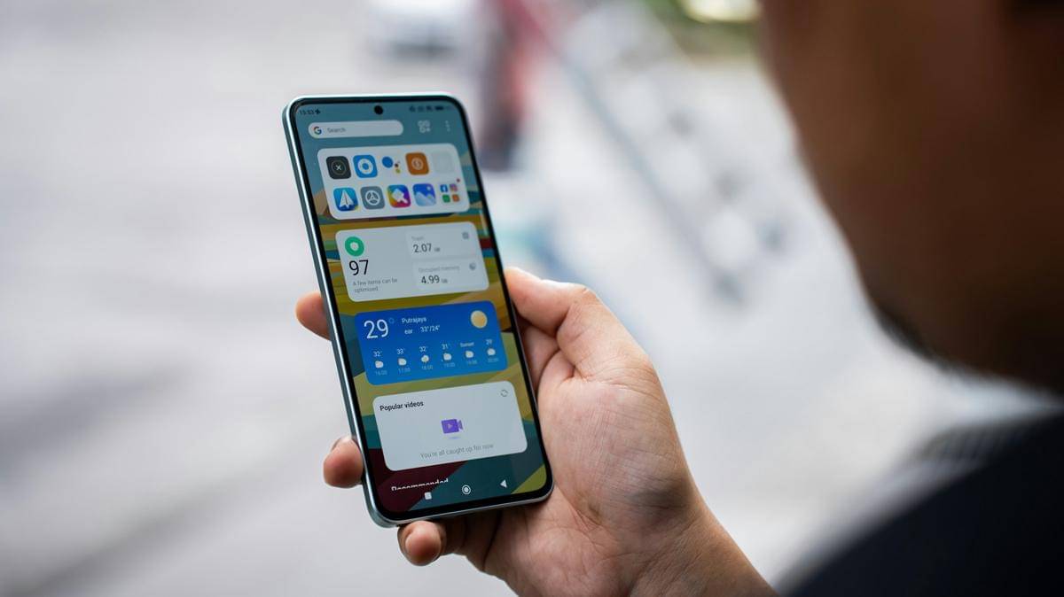 Seseorang memegang smartphone di tangan kanannya.