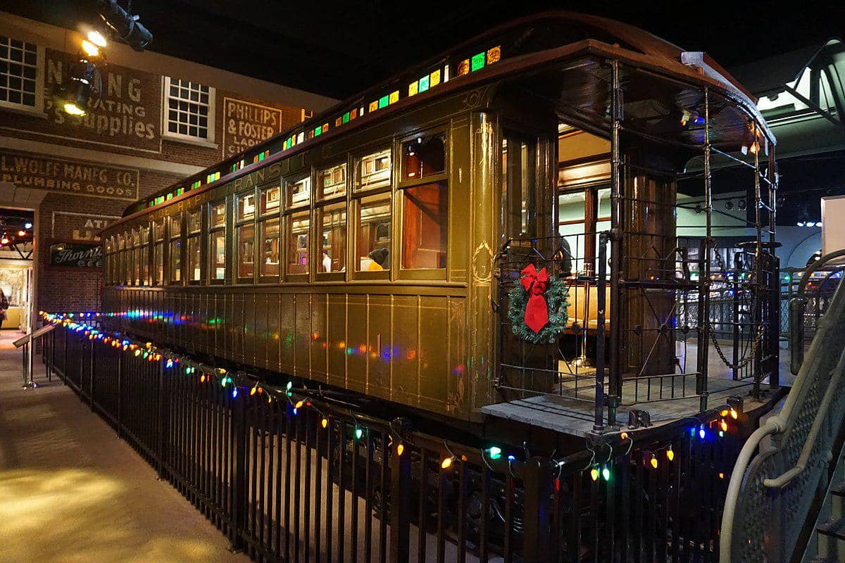 Kereta No. 1 South Side Rapid Transit berwarna cokelat tua dipamerkan di Museum Sejarah Chicago dengan hiasan lampu dan karangan bunga.
