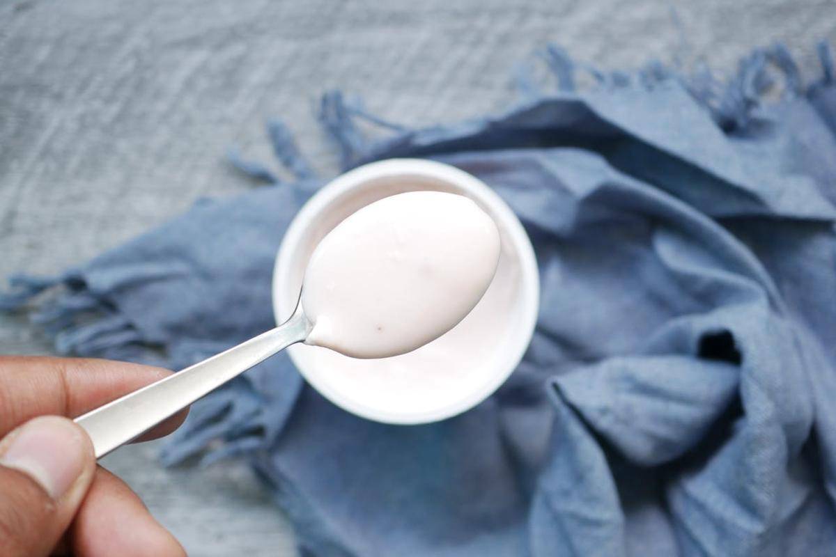 Seseorang menyendok yoghurt.
