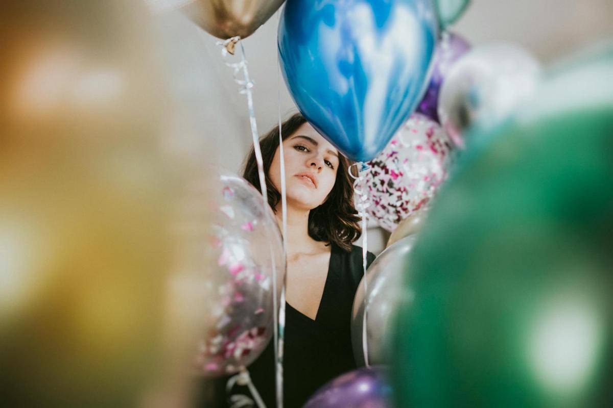 perempuan yang dikelilingi balon helium