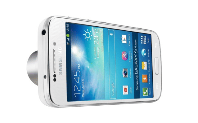 Smartphone Samsung Galaxy S4 Zoom berwarna putih dengan layar menyala menampilkan antarmuka Android dan lensa kamera besar di bagian belakang.