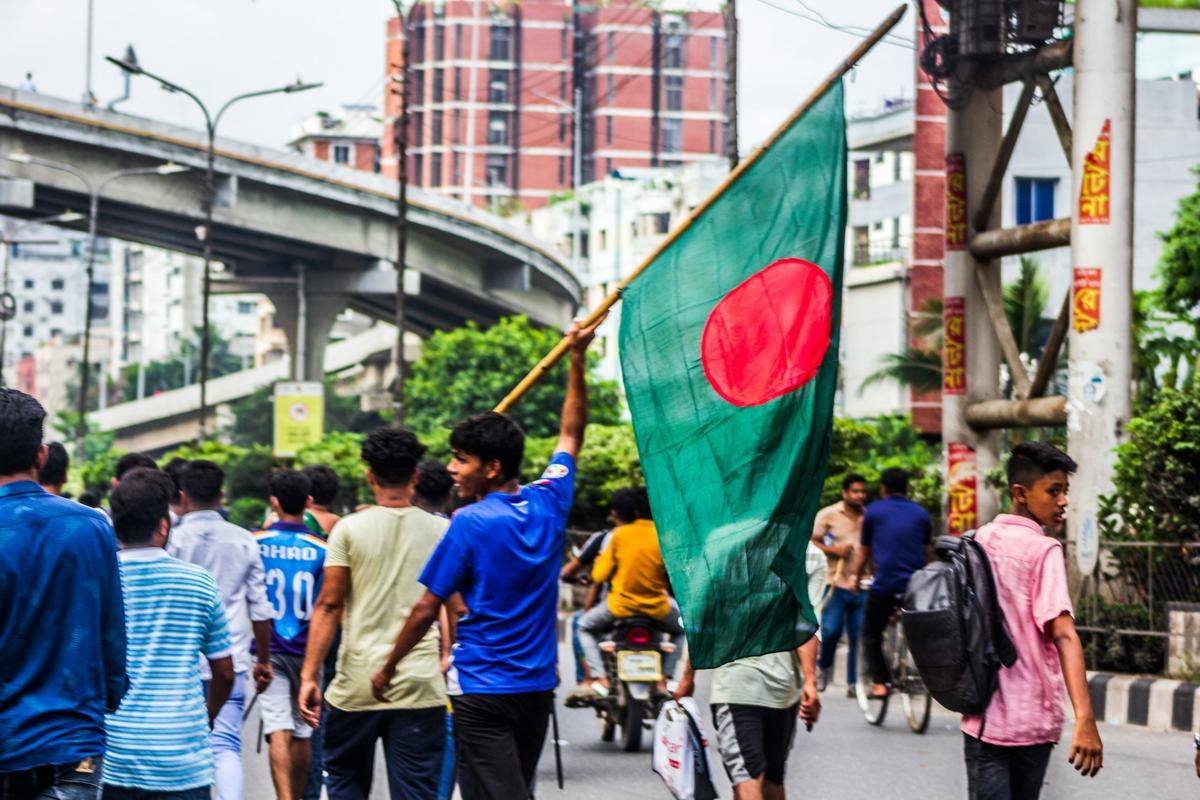 remaja membawa bendera Bangladesh (unsplash.com/Bornil Amin)