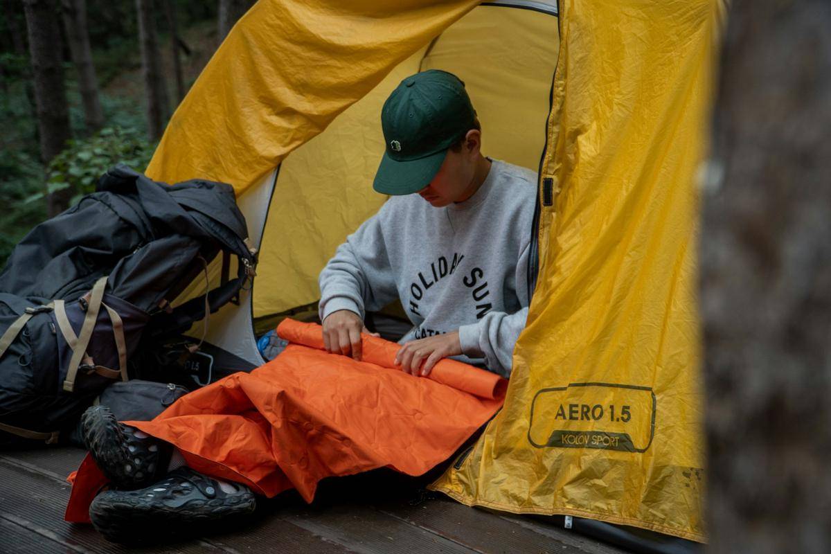 ilustrasi pendaki melipat sleeping pad (unsplash.com/Chewool Kim)