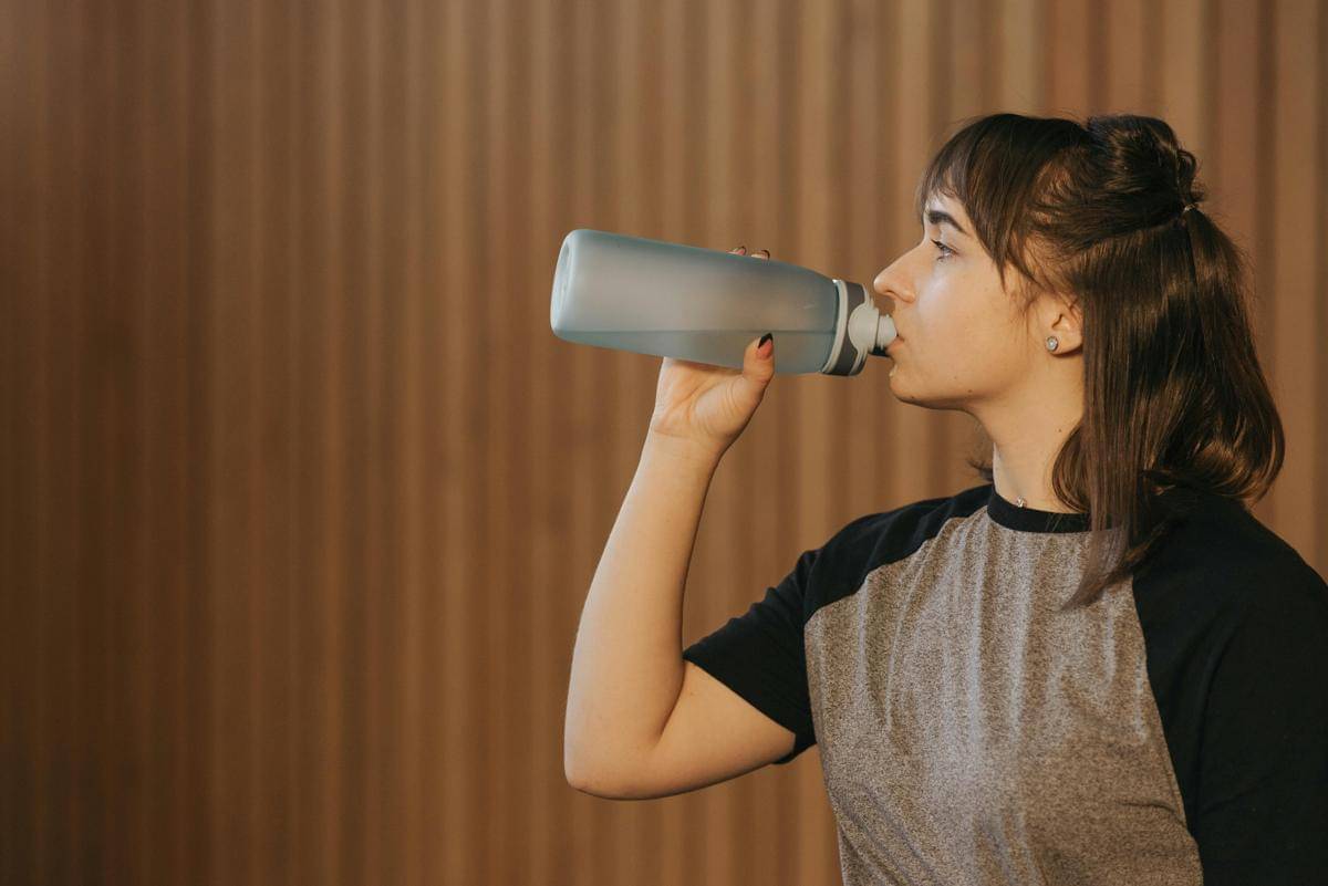 ilustrasi minum dengan botol isi ulang