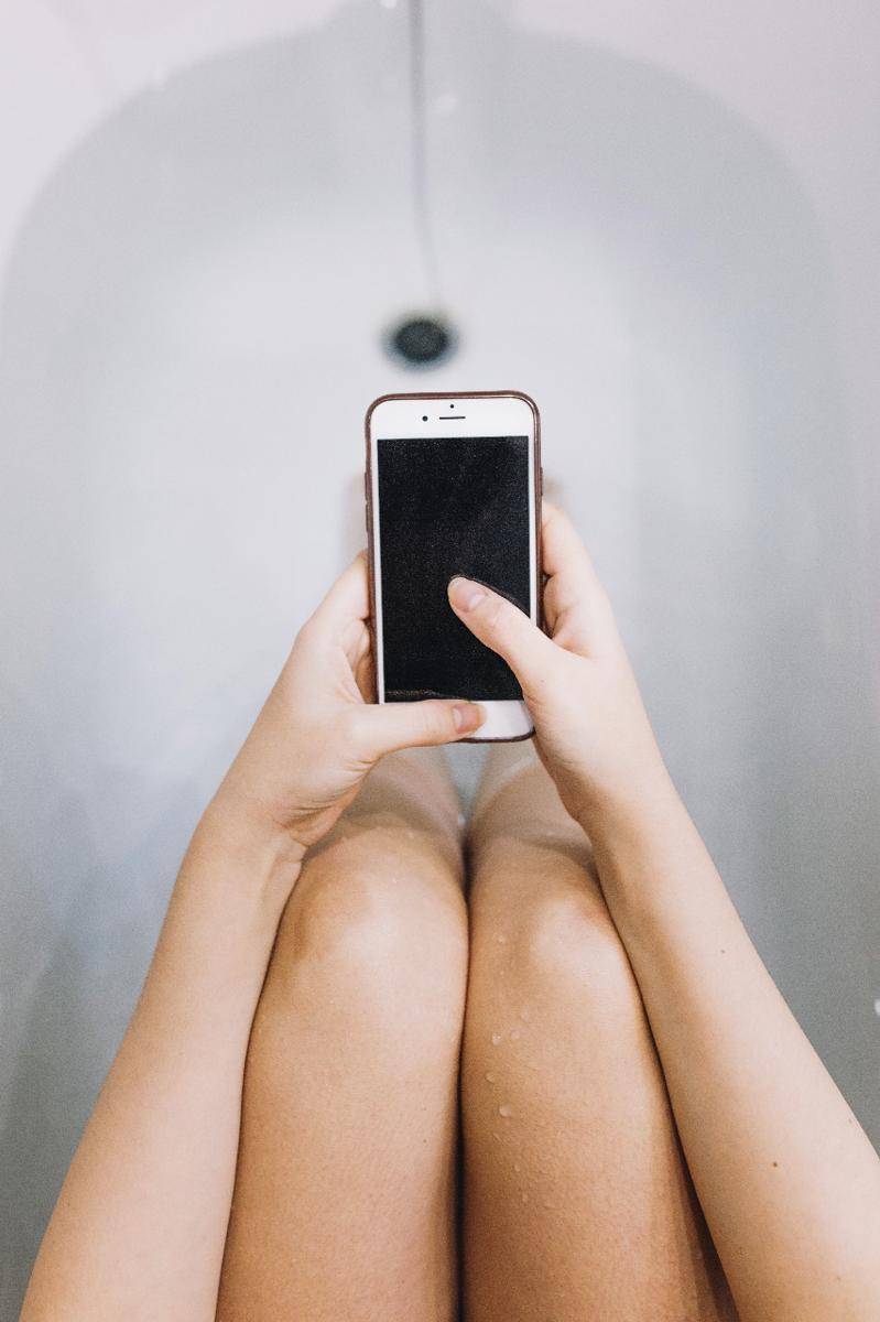 Ilustrasi wanita bermain handphone di toilet. (https://www.freepik.com/)