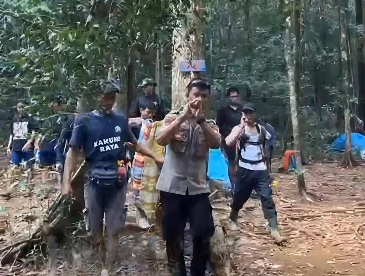 Anggota polisi bersama relawan Pokdarwis Belangian menandu pendaki remaja yang cedera di Pos 3 menuju puncak Gunung Kahung, Kalimantan Selatan. (Dok/istimewa)