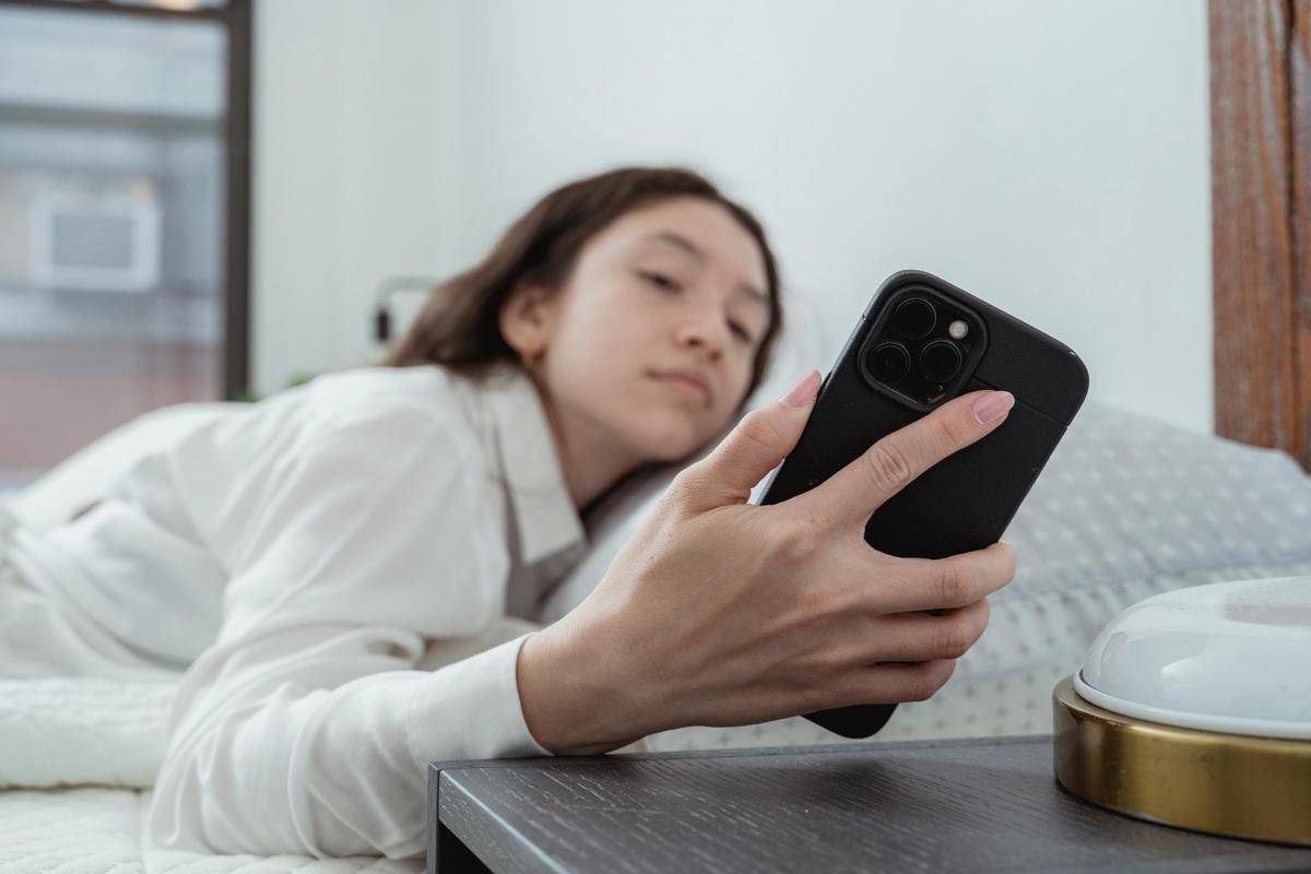 ilustrasi wanita bangun tidur bermain handphone (pexels.com/Miriam Alonso)