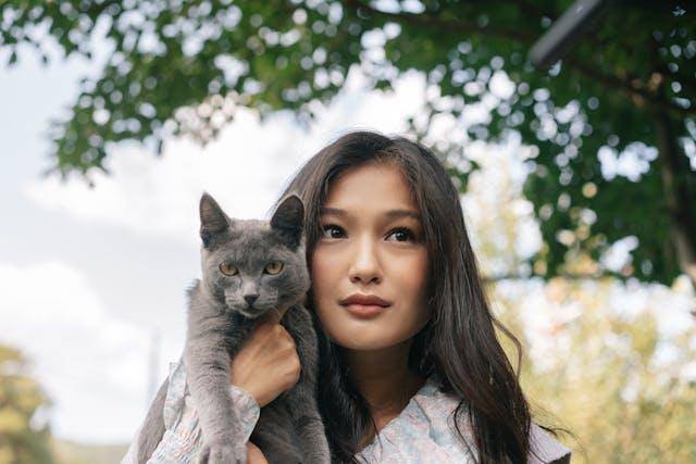 Ilustrasi seorang wanita membawa kucing
