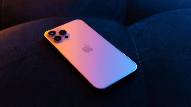 ilustrasi iPhone varian Pro yang disinari semburat warna oranye (unsplash.com/Erwi)