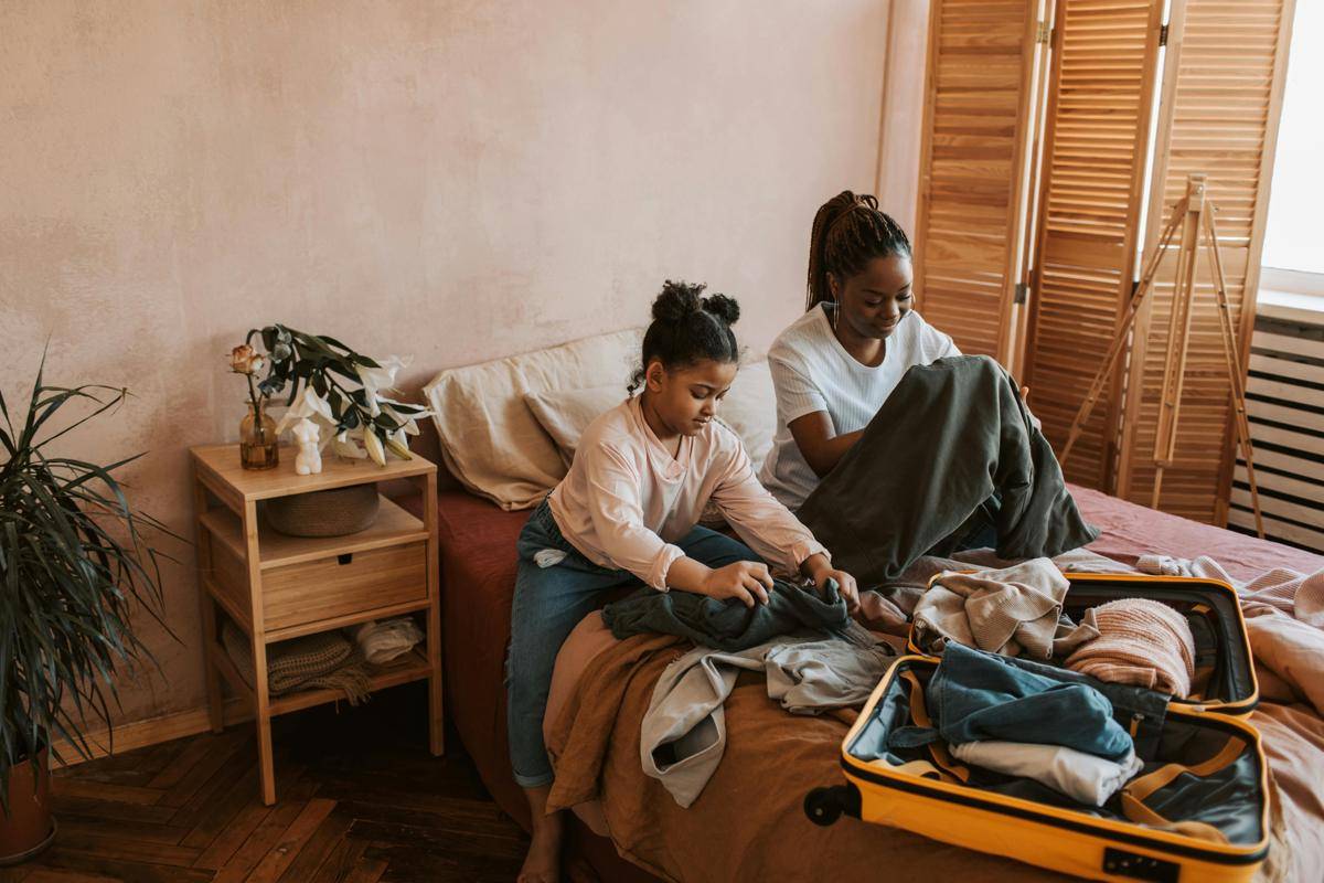 Ibu dan anak sedang menaata koper. (pexels.com/Vlada Karpovich)