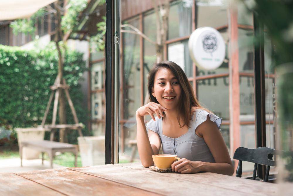ilustrasi seorang perempuan di kafe (freepik.com/tirachardz)
