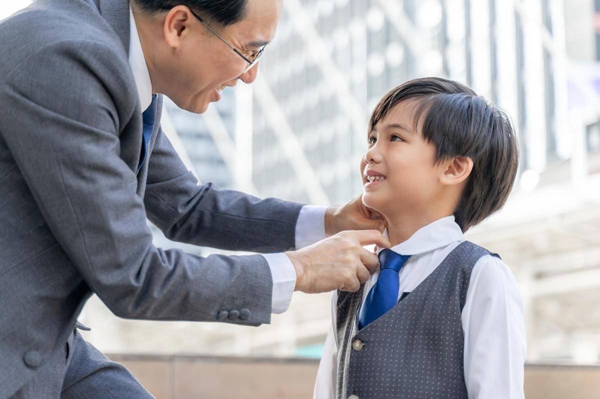 Ilustrasi ayah merapikan baju anak (freepik.com/jcomp)