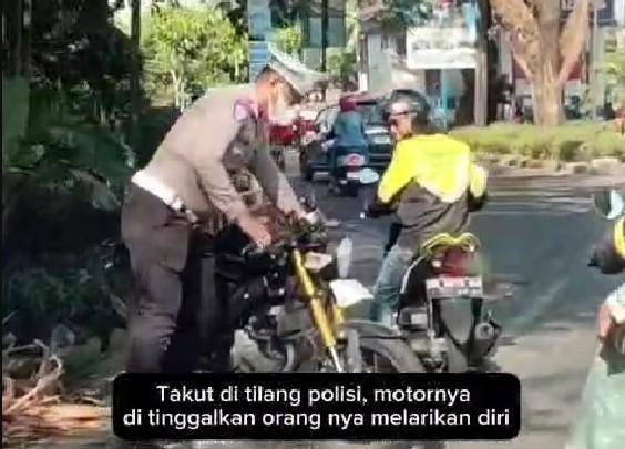 Tangkapan layar video anggota polisi di Makassar mengamankan sepeda motor yang ditinggal pemiliknya yang kabur karena takut ditilang, Kamis (31/7/20205)/Istimewa
