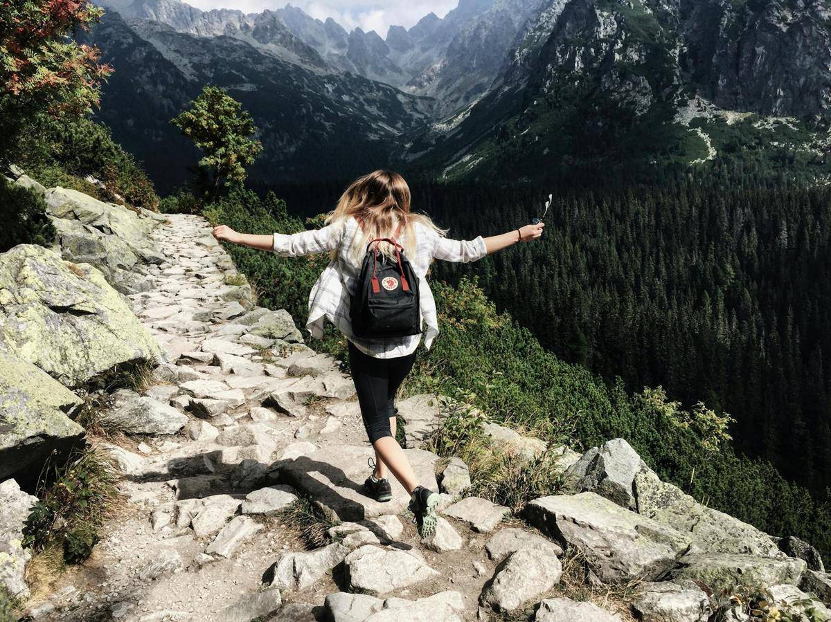 seseorang berjalan dengan gembira di lereng gunung (pexels.com/Nina Uhlikova)