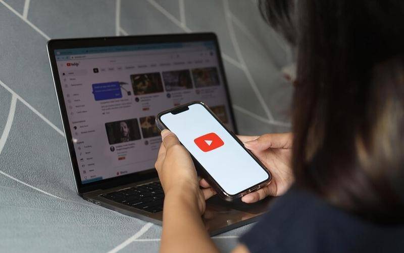 ilustrasi pengguna dewasa sedang membuka YouTube di smartphone (freepik.com/garakta_studio)