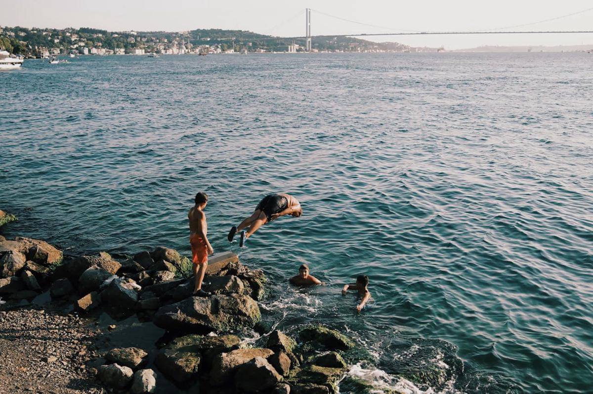 ilustrasi orang-orang yang berenang di tepi pantai 