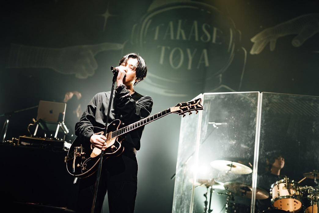 TakaseToya saat bernyanyi sembari bermain gitar