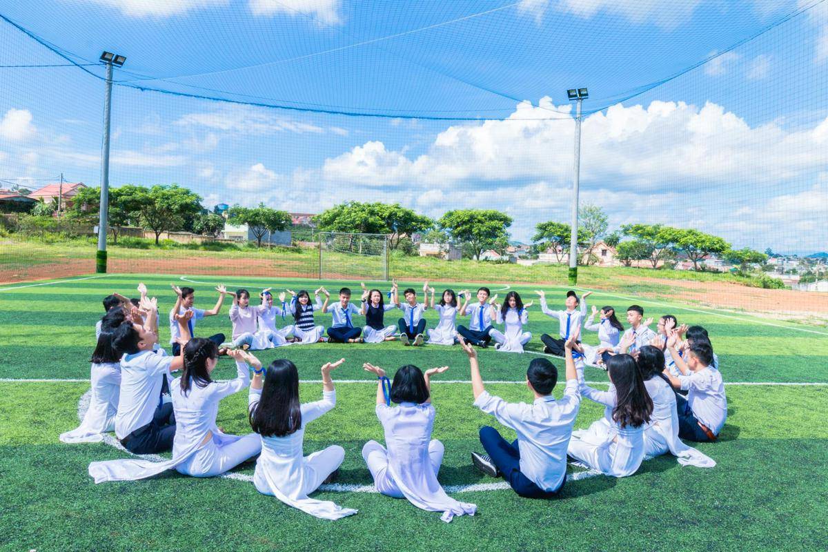 ilustrasi sekelompok siswa yang duduk bersama di tengah lapangan sekolah (pexels.com/Chu Chup Hinh)
