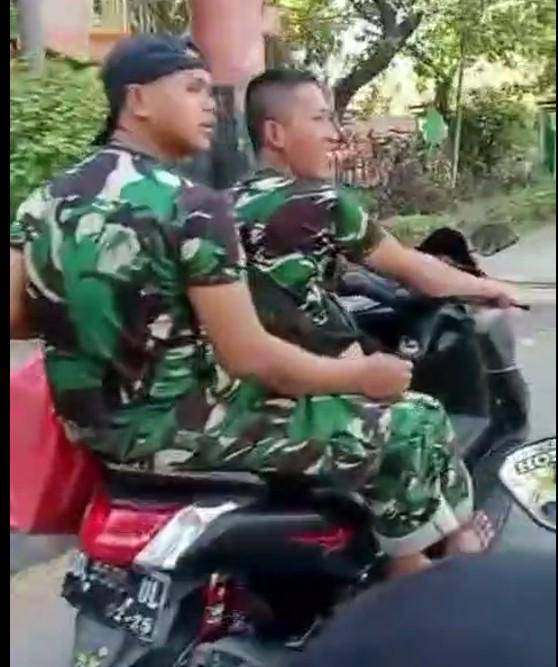 Dua pria berbaju loreng mengendarai sepeda motor di Makassar tidak ditilang saat melintas di depan razia polisi, Rabu (6/8/2025).