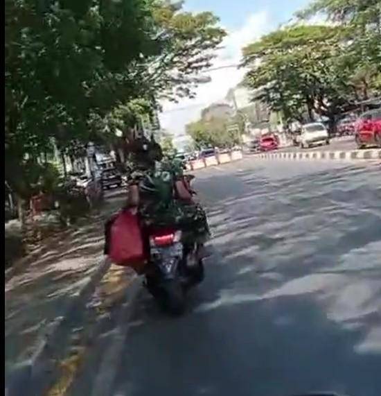Dua pria berbaju loreng mengendarai sepeda motor di Makassar tidak ditilang saat melintas di depan razia polisi, Rabu (6/8/2025).
