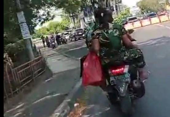 Dua pria berbaju loreng mengendarai sepeda motor di Makassar tidak ditilang saat melintas di depan razia polisi, Rabu (6/8/2025).