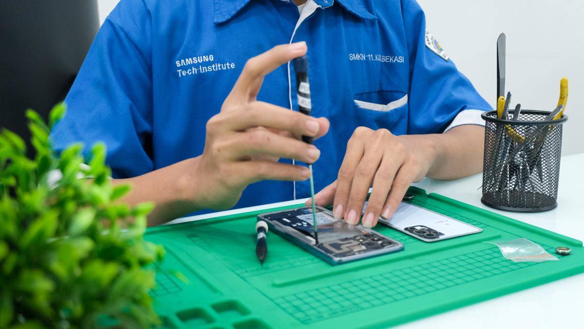 Peserta STI tengah memperbaiki smartphone saat PKL di Samsung Service Centre.jpg