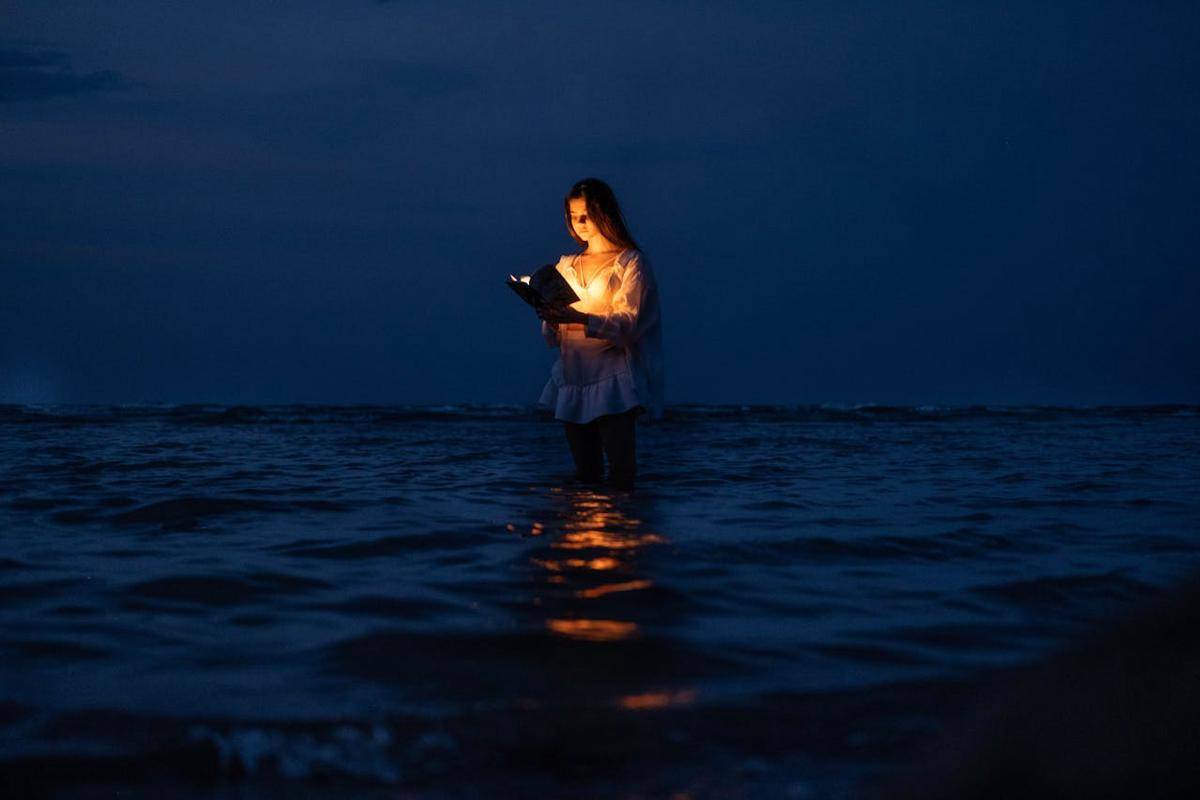 ilustrasi perempuan memegang lentera di tengah laut (pexels.com/Leyla Qəhrəmanova)